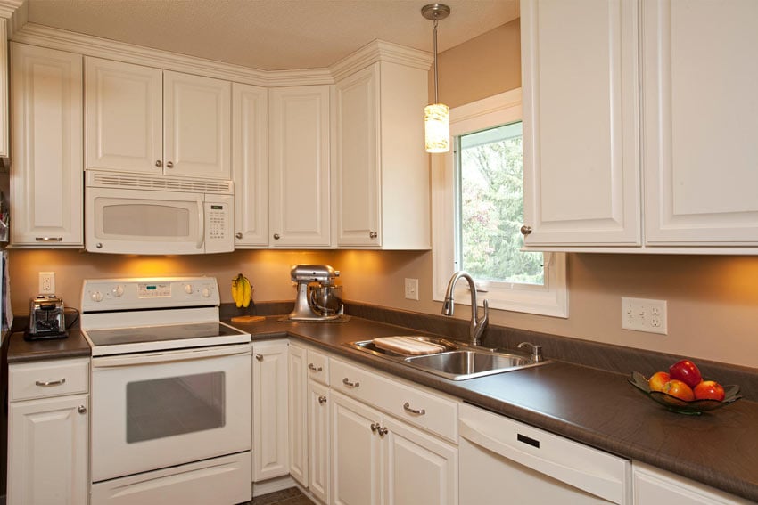 Kitchen with white cabinets and modern hanging light